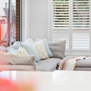 sofa couch beside white shutters open