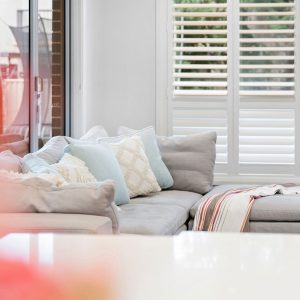 sofa couch beside white shutters open